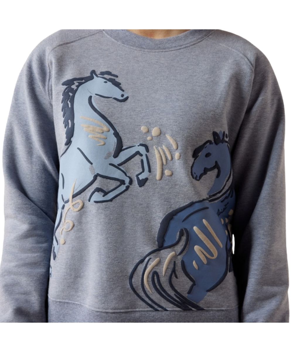 Close-up view of the playful puff screen-printed horse graphic on the girl's blue grey sweatshirt