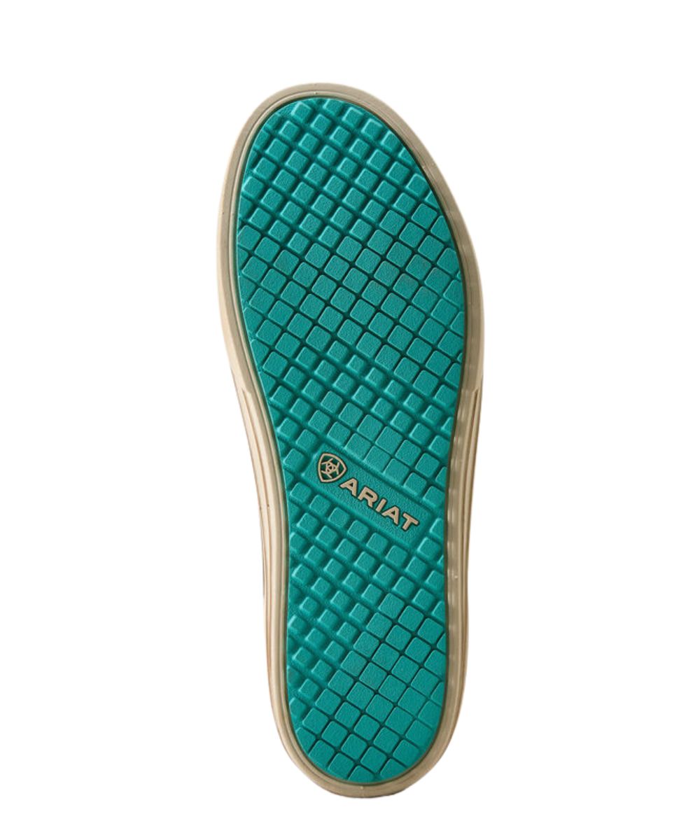 The bottom sole of a shoe, featuring a textured teal green diamond-patterned tread with the ARIAT logo in gold, surrounded by a beige rubber edge, on a solid white background.