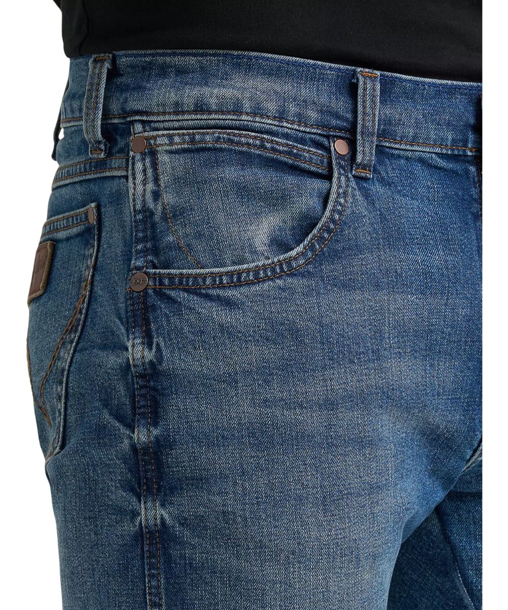 Close-up view of the low rise, five pocket styling, and harris medium wash denim color