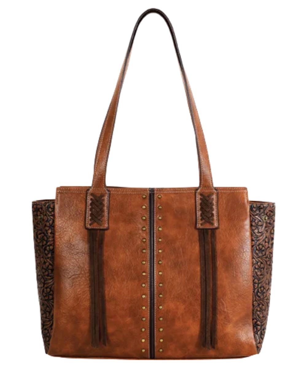 Front view of the women's tan concealed carry tote featuring the brown center seam and floral embossed sides, brass studs, and brown tassels