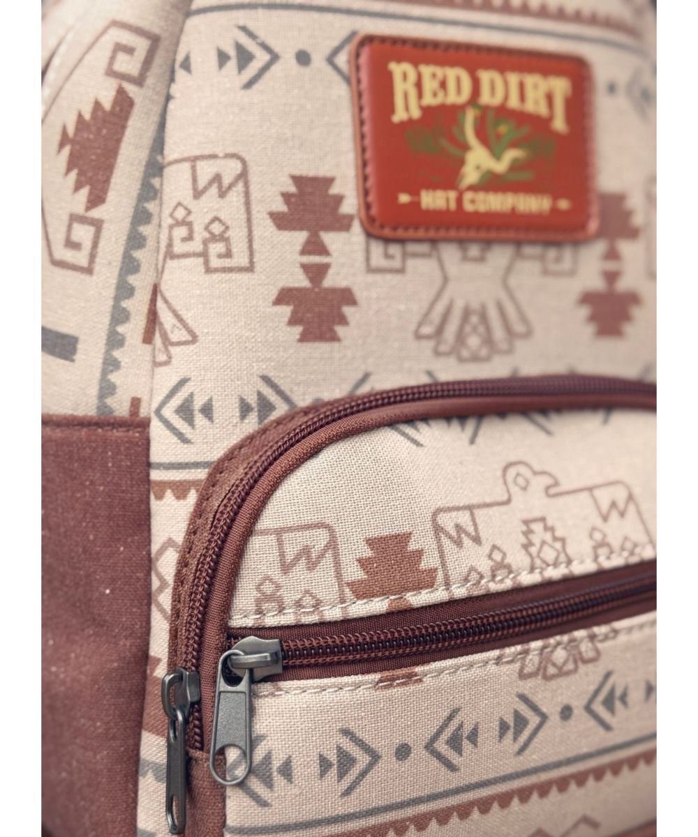 Close-up view of the tan mini backpack featuring the thunderbird print