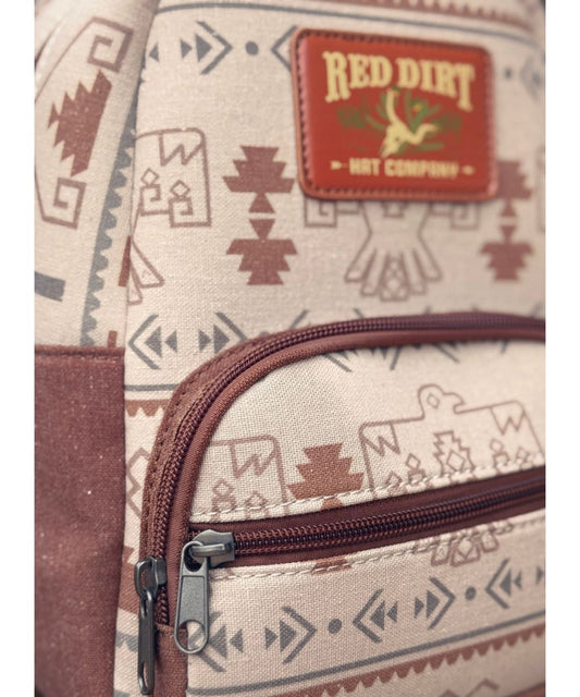 Close-up view of the tan mini backpack featuring the thunderbird print