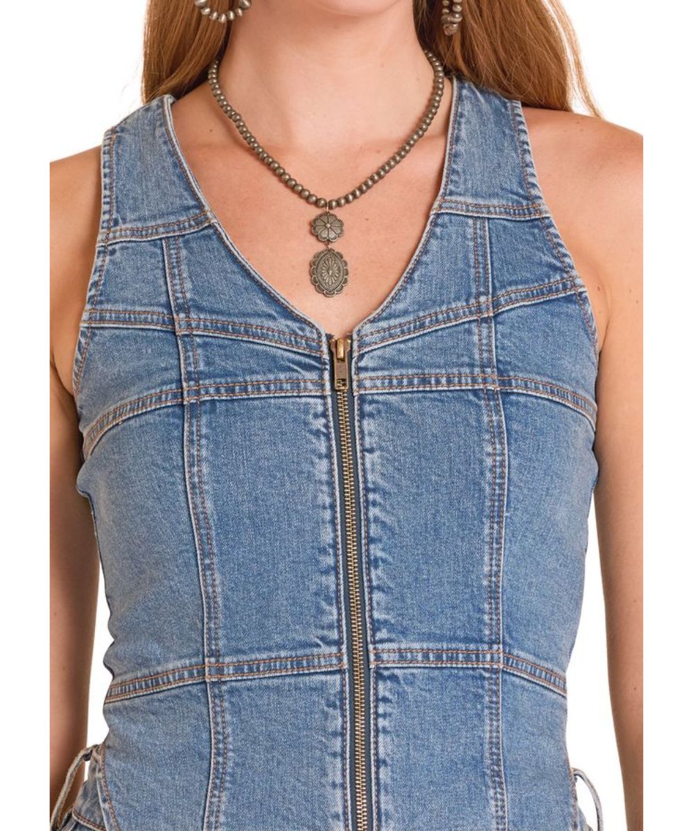 Close-Up Fabric View Of The Women's Zip-Up Denim Vest Featuring A V-Neckline And Seam Detailing