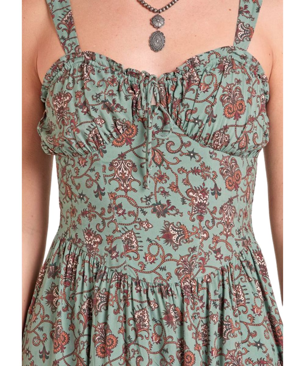 Close-up view of the v-neckline with a self-tie closure, corset bodice, and floral print on the women's hunter green midi length dress