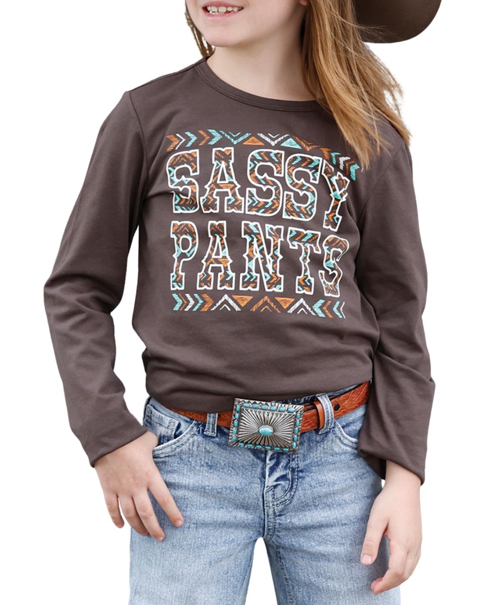 Front view of the girl's brown Cruel Girl long sleeve graphic tee freaturing the southwestern screen-printed design on the front that reads: "Sassy Pants"