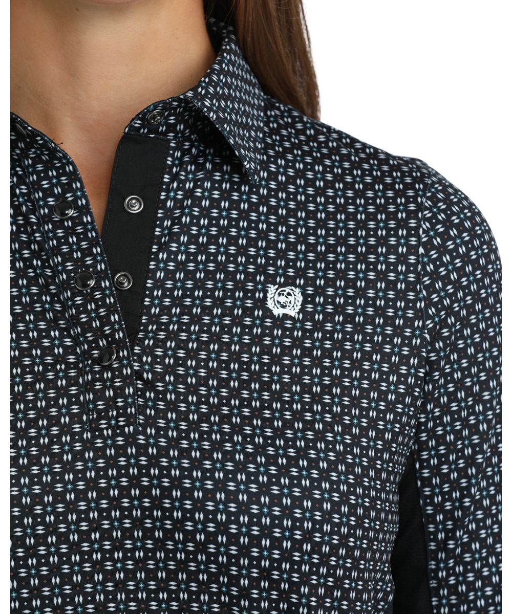 Close-up view of the white geometric print, black knit panels, 1/4 pearl snap placket, and spread collar