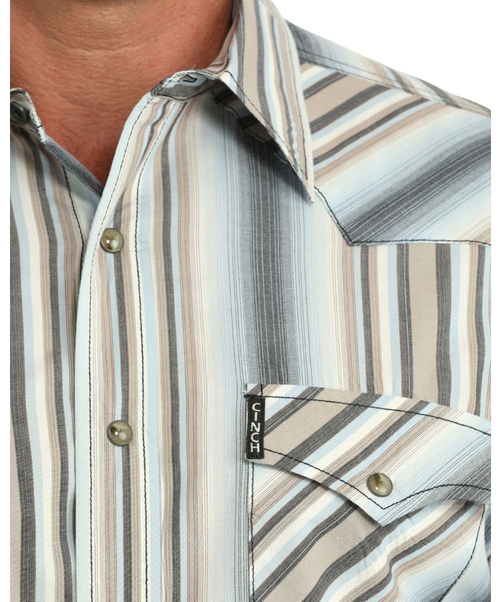 Close-up view of the multicolor striped print, western yokes, brown marble snaps, and the snap flap chest pockets with a logo label