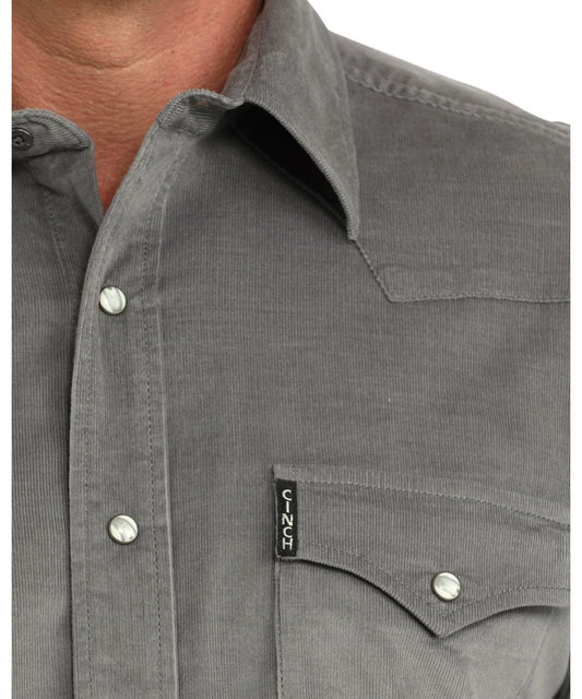 Close-up view of the solid grey corduroy shirt featuring the marble snaps and a logo label at the left chest pocket