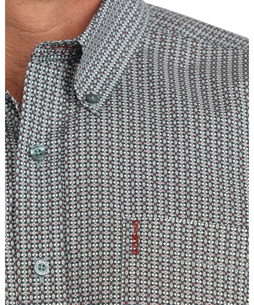 Close-up view of the men's blue long sleeve button down shirt featuring the geometric print, chest pocket, blue buttons, and button down collar