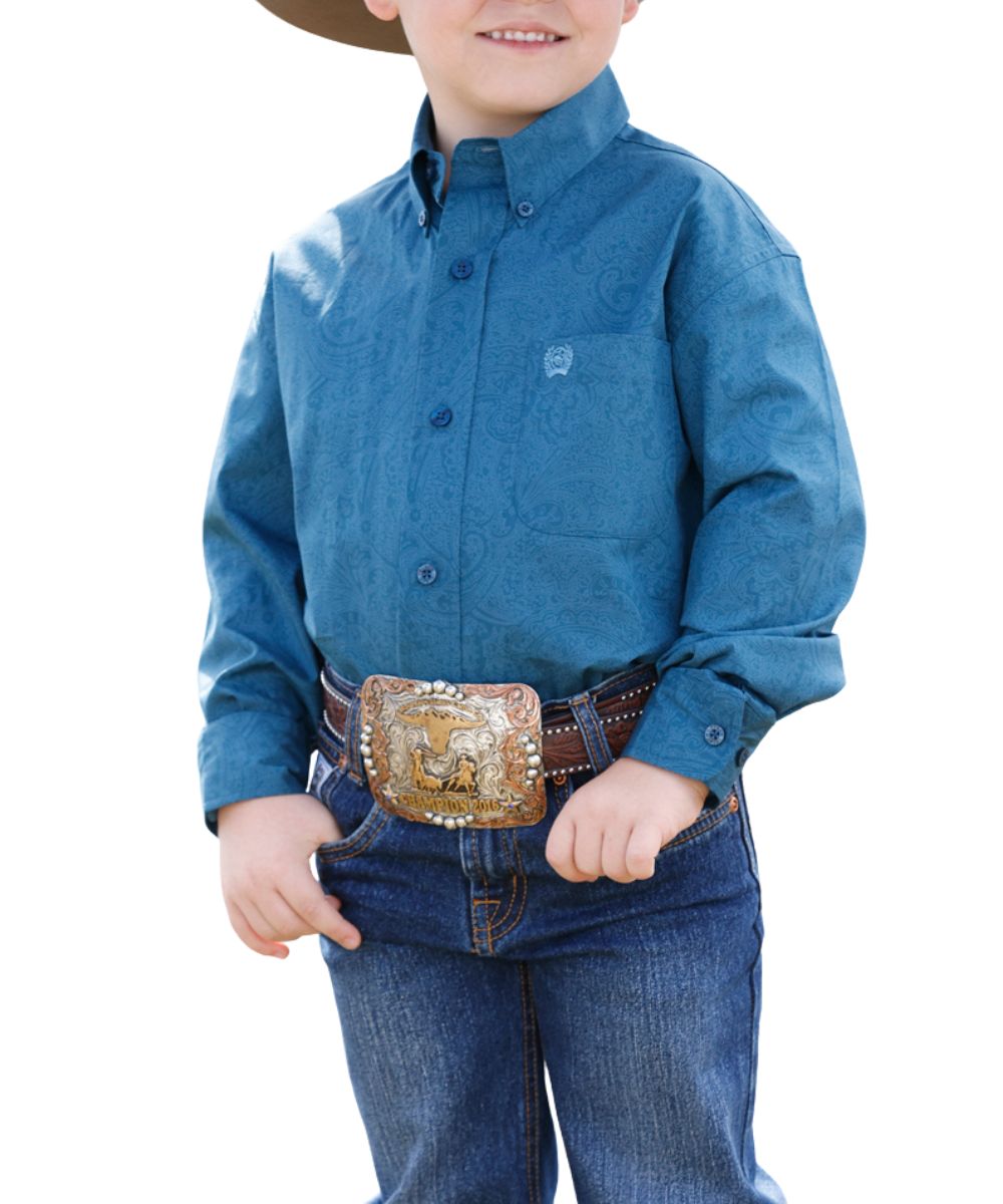Front view of the boy's blue Cinch long sleeve button down shirt featuring the button down collar, blue buttons, chest pocket, and paisley print