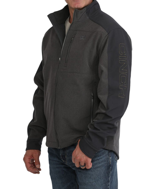 Side view of the men's brown bonded jacket featuring the color blocked sleeve panels, snap cuffs, and the logo embroidery at the chest pocket and down the left sleeve