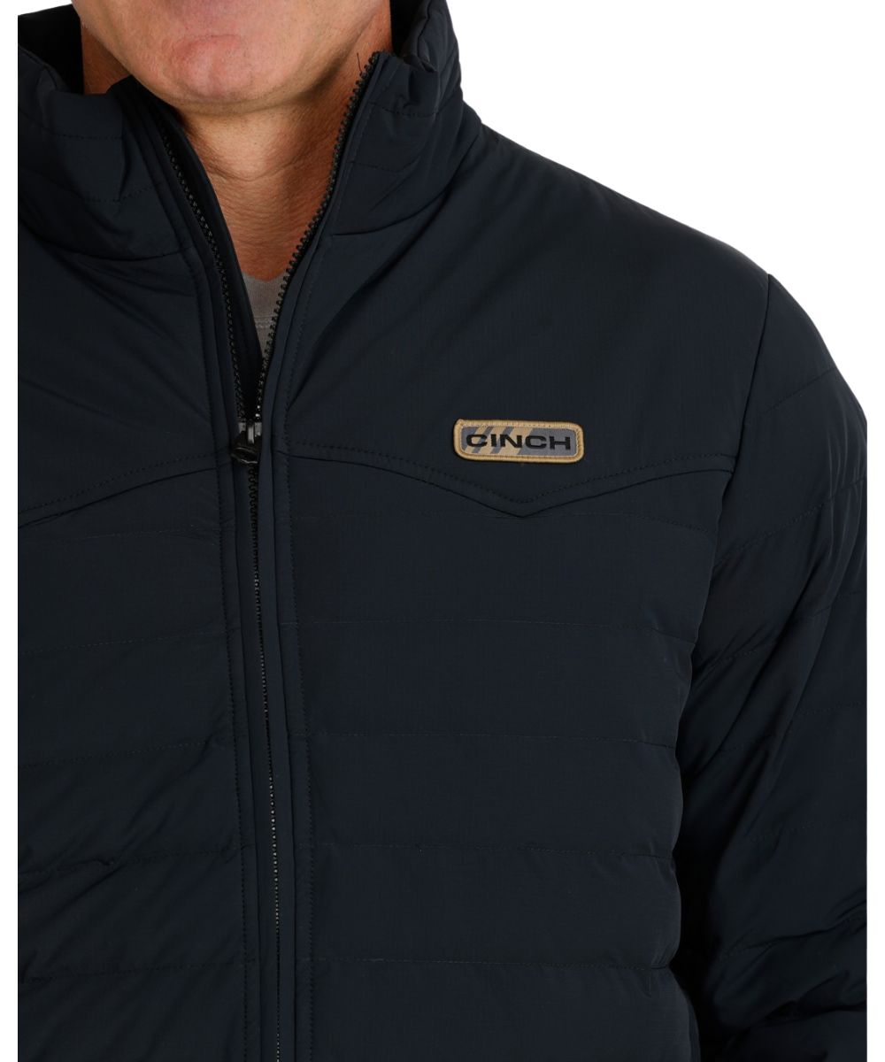 Close-up view of the men's black quilted jacket featuring the single point western yokes and a logo label at the left chest