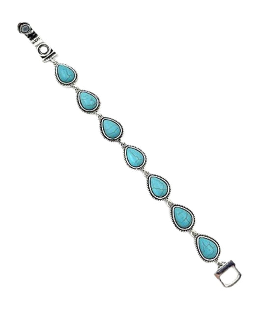 Women's silver tone bracelet featuring the teardrop shaped charms filled with turquoise stones and a magnetic closure