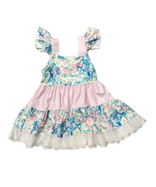 Back view of the girl's sleeveless ruffle dress in white featuring a floral frontier print