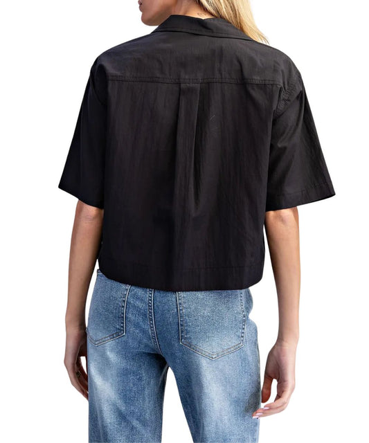Back view of the women's black short sleeve button down blouse featuring the straight back yoke with a box pleat