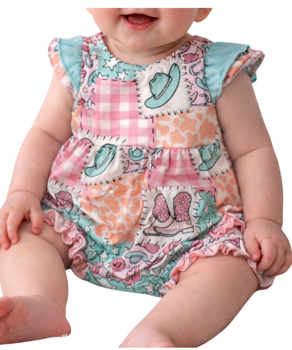 Baby onesie with a colorful western patchwork design featuring cowboy hats, boots, stars, and animal prints in pink, teal, and peach tones, styled with short ruffled sleeves and leg openings.