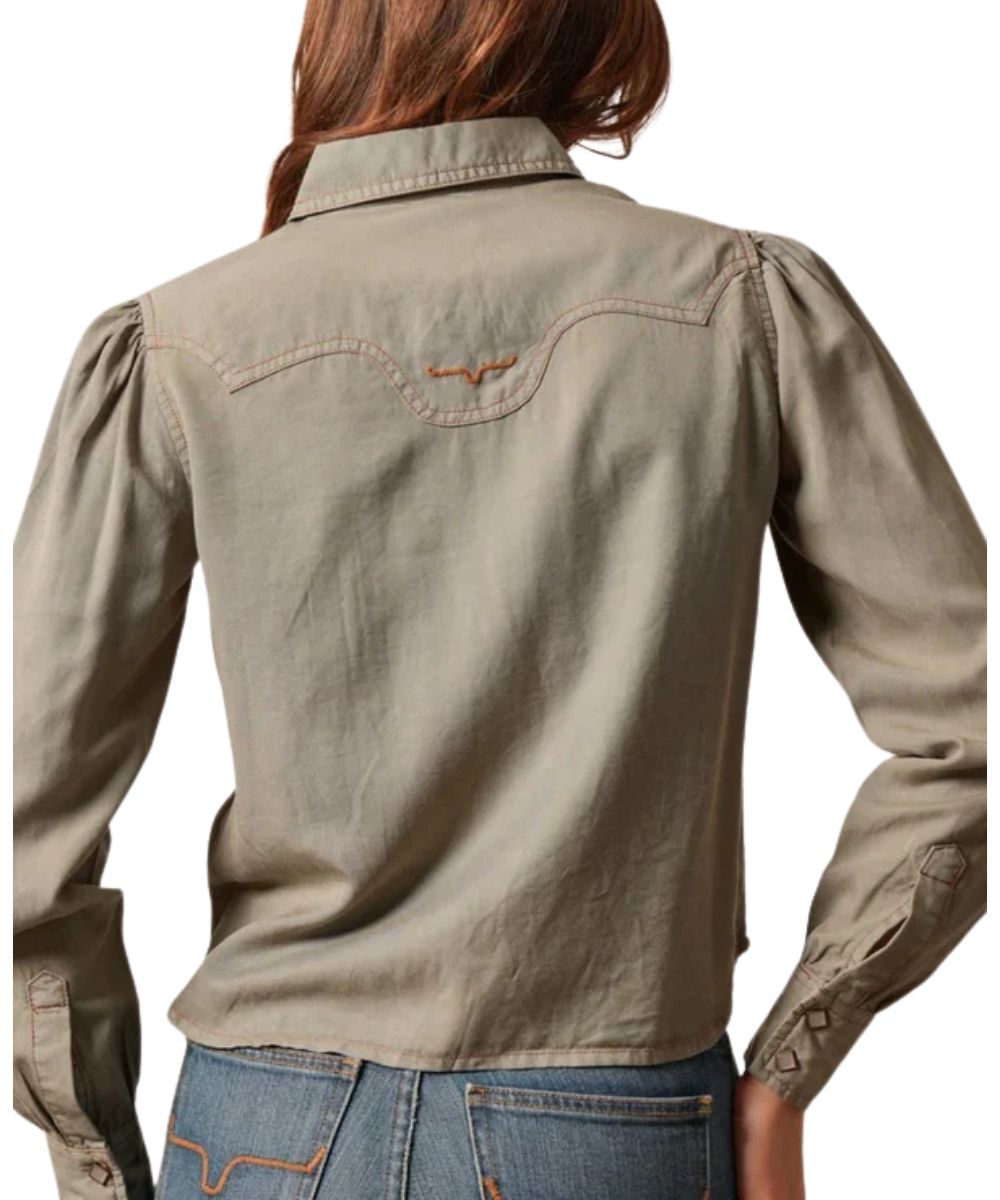 Back view of the women's moss green long sleeve pearl snap shirt featuring the cropped length, curved back western yoke with logo embroidery, and curved hem