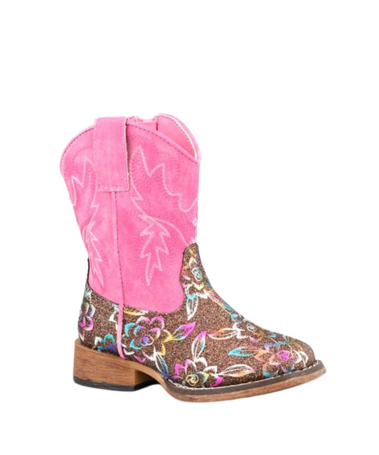A single western-style cowboy boot with a bright pink suede shaft, a brown glittery footstock covered in colorful floral embroidery, and a stacked brown heel, shown against a plain white background.