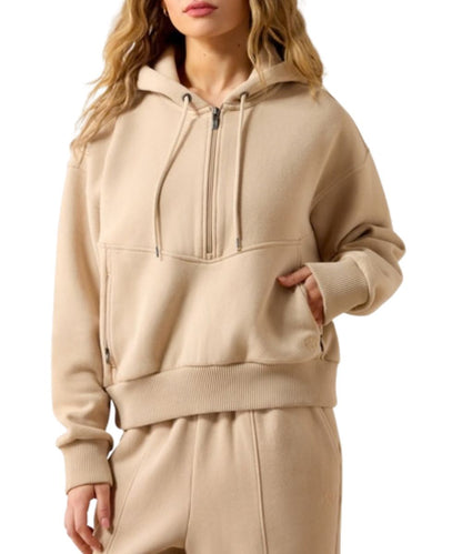 Front view of the women's moonstone/tan Ariat 1/2 zip sweatshirt featuring the hooded collar with adjustable drawstring, zippered hand pockets, and the 1/2 zip closure