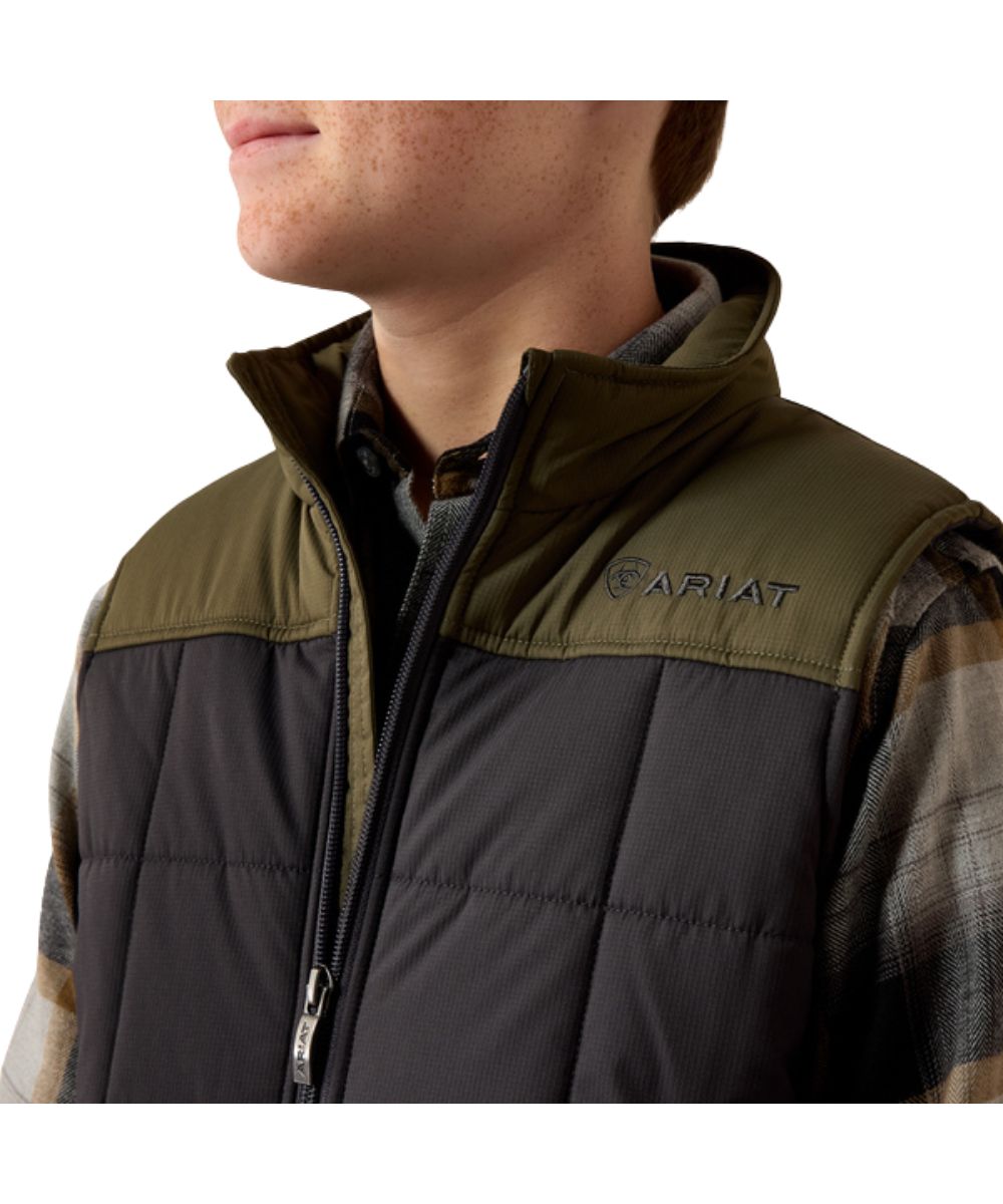 Close-up view of the color blocked detailing on the boy's phantom and olive insulated vest featuring the logo embroidery on the chest and back collar