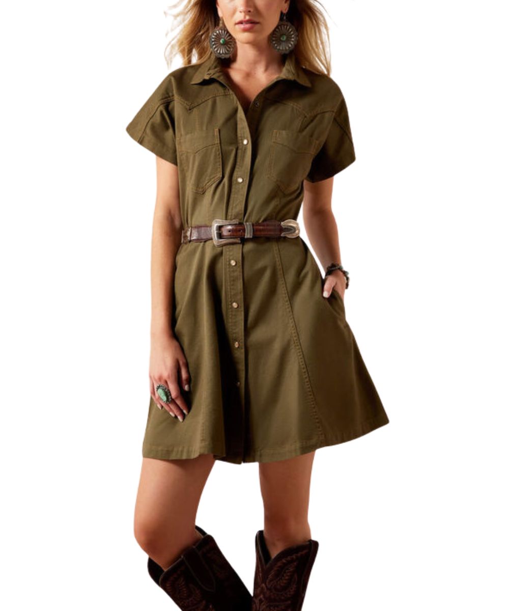 An olive green short-sleeve shirt dress with a button-down front, chest pockets, and a brown belt, modeled with brown cowboy boots against a white background.