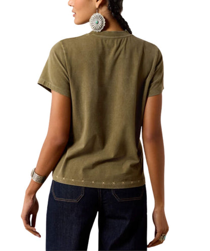 A woman shown from the back wearing a short-sleeve olive green t-shirt with silver star embellishments along the hem, paired with dark blue jeans.