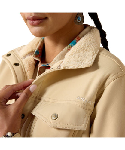 Close-up view of the spread collar and logo embroidery on the solid printed irish cream women's long sleeve softshell jacket