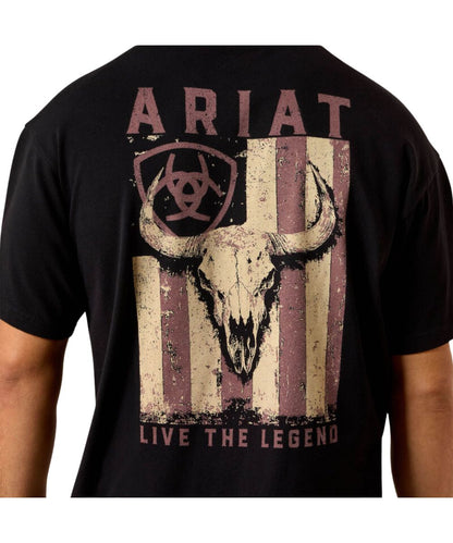 A black short-sleeve t-shirt featuring a distressed front graphic with the word 'ARIAT' at the top, a biohazard symbol inside a shield, a bull skull over vertical red and beige stripes, and the text 'LIVE THE LEGEND' at the bottom.