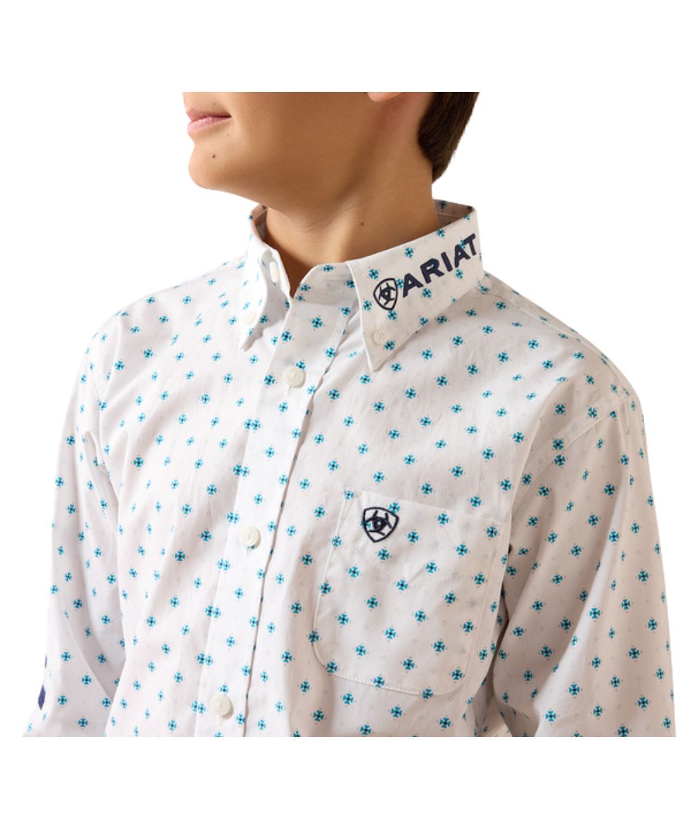 Close-up view of the multi blue geometric print featuring the logo embroidery on the sleeve, collar, and pocket, single open chest pocket, and button down collar