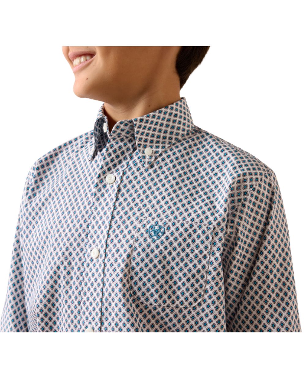Close-up view of the boy's white long sleeve button down shirt featuring the blue geometric print and white buttons