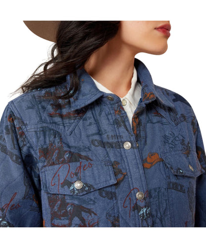 Close-up view of the retro rodeo print on the women's blue lightweight insulated jacket featuring the spread collar, snap front closure, snap flap chest pockets, and single point western yokes