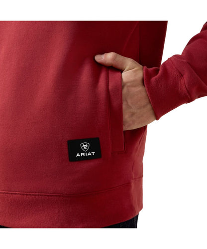 Close-up view of the kangaroo pocket on the men's brick red pullover