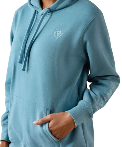 Close-up view of the women's hoodie featuring the logo embroidery at the sleeve and chest, and the kangaroo pocket
