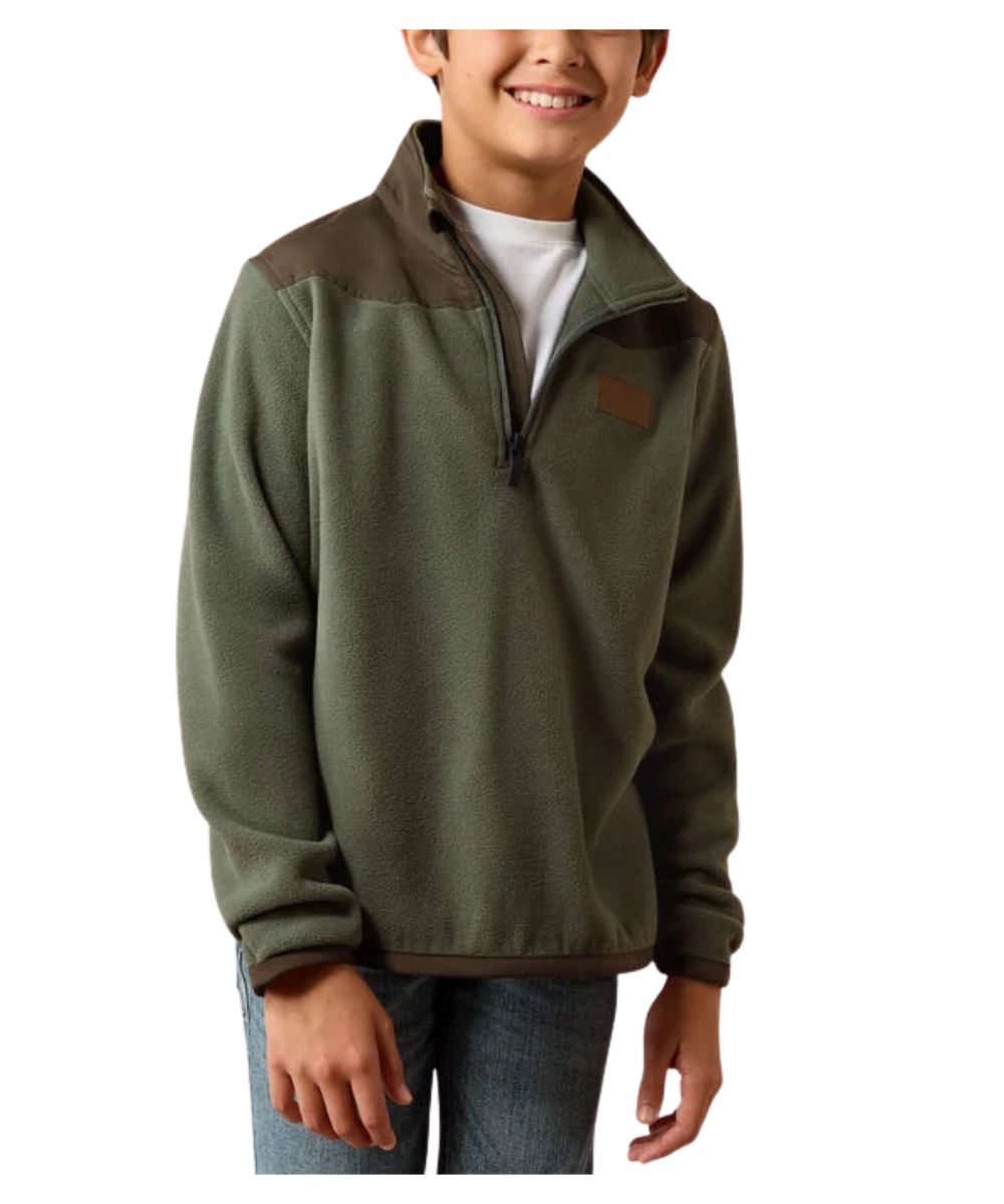 A child wearing an olive green quarter-zip fleece pullover with brown shoulder and hem accents, paired with a white t-shirt and blue jeans, shown against a plain white background.