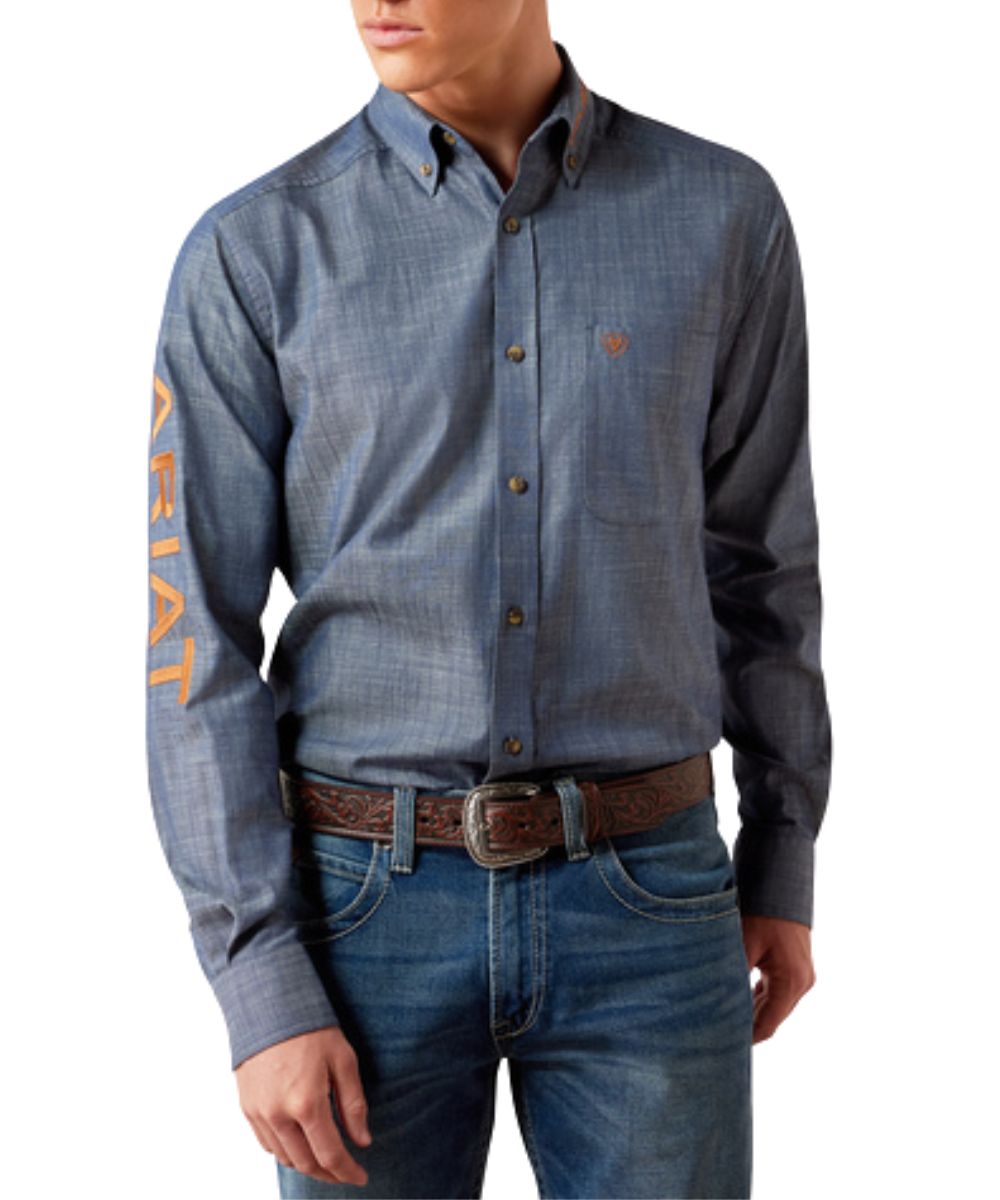 Front view of the men's Ariat Team Logo Twill Fitted Button Down Shirt in chambray blue with saddle brown logo embroidery at the sleeve, collar, and back
