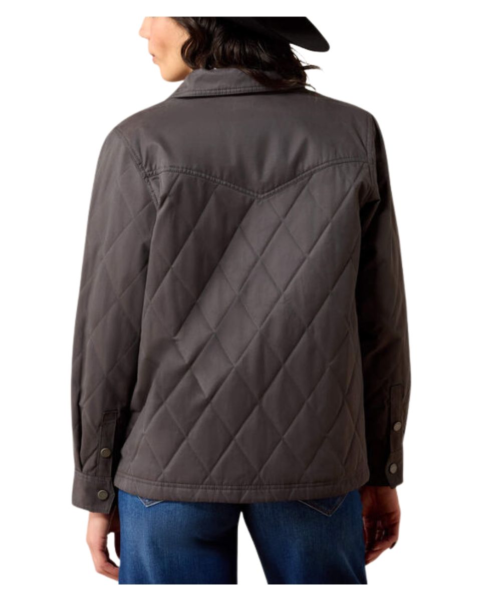 A person shown from the back wearing a dark gray quilted jacket and blue jeans against a plain white background.