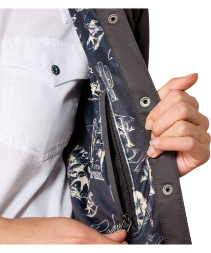 Close-up of a person holding open a dark jacket or overshirt to show the interior lining, which has a navy and white graphic print. The person is also wearing a white shirt.