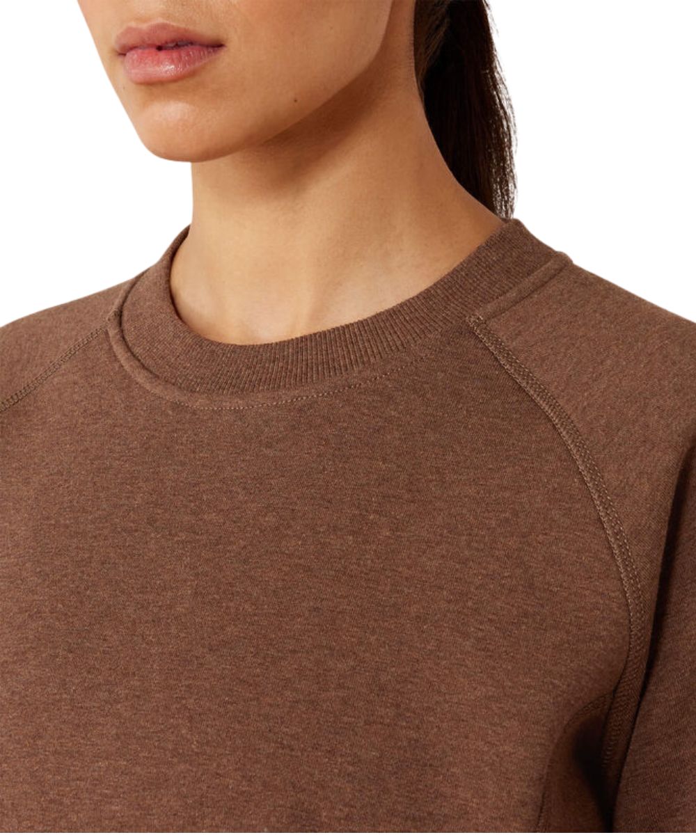 Close-up of a woman wearing a brown crewneck sweatshirt, showing the ribbed collar, shoulder seam, and textured fabric