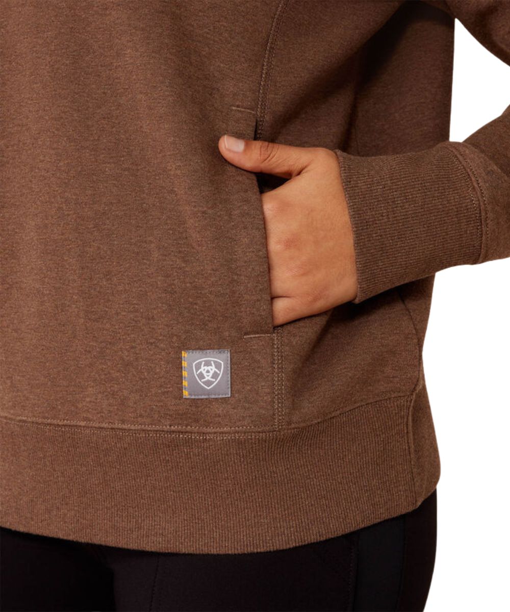 Close-up view of the women's brown crew neck sweatshirt featuring the welt hand pockets and ribbed hem