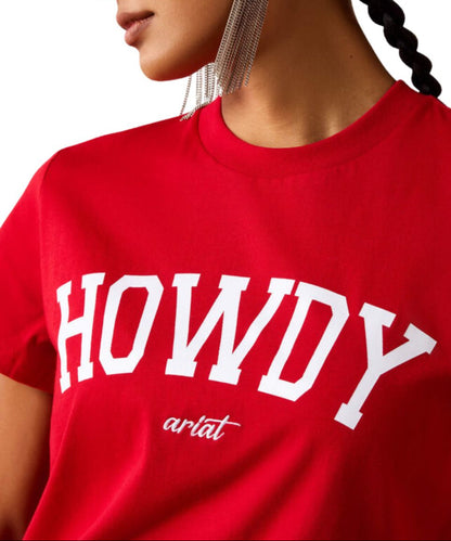 A close-up of the women's bright crimson red crewneck t-shirt with 'HOWDY' printed in large white varsity letters and 'ariat' in white embroidery underneath.