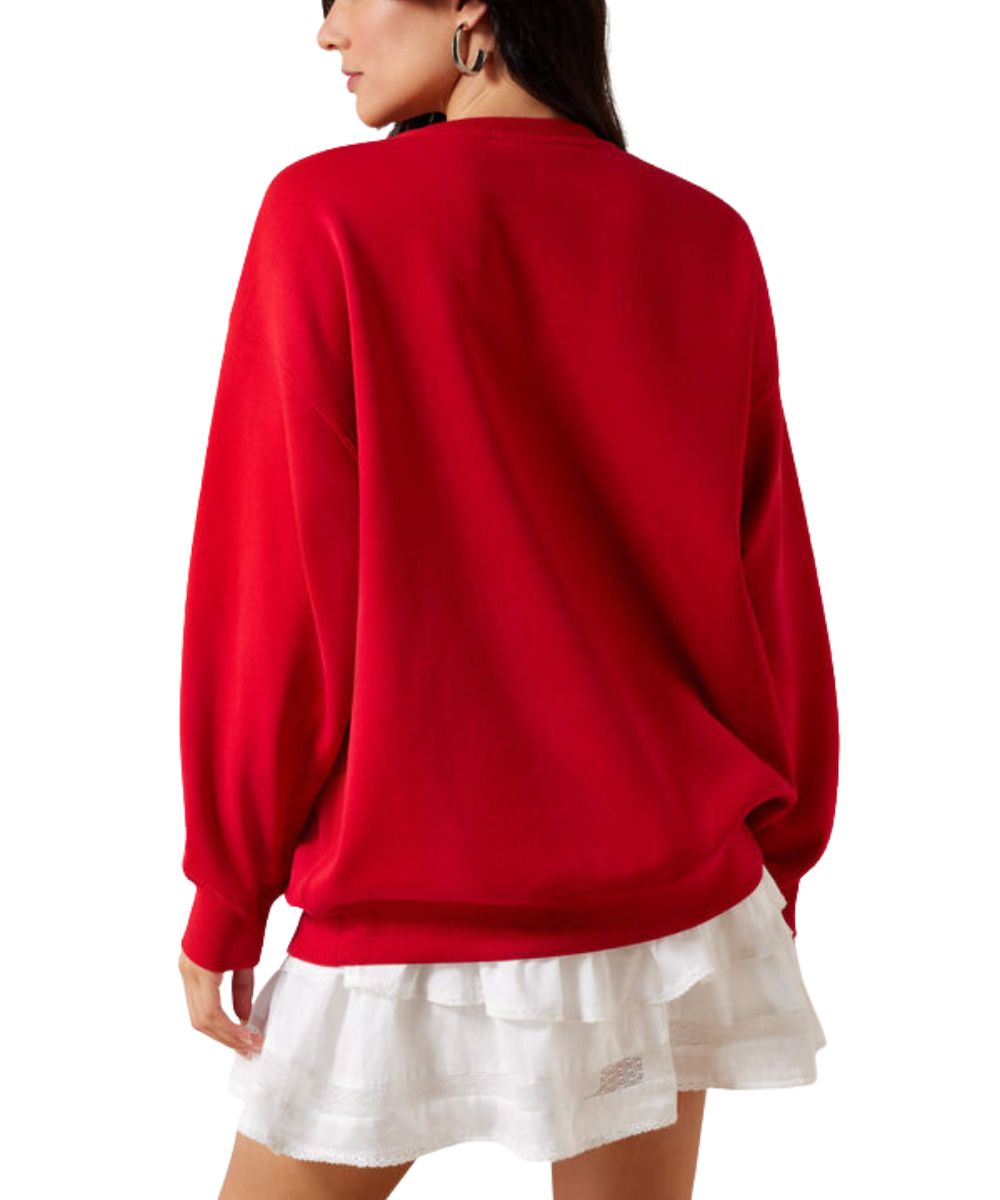 A woman shown from the back wearing a bright red oversized long-sleeve sweatshirt over a white ruffled mini skirt, against a plain white background.