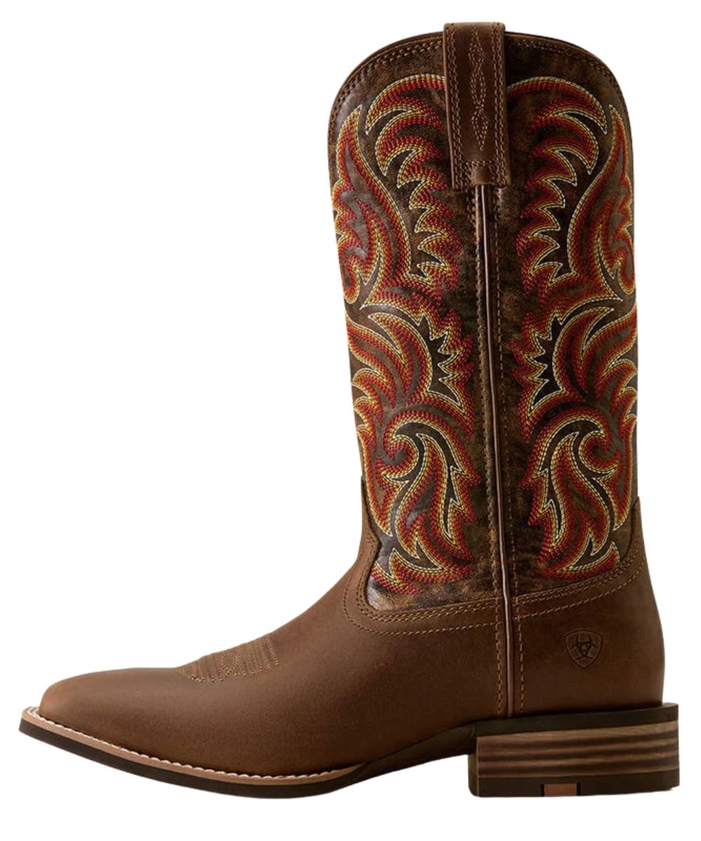 A brown leather cowboy boot with intricate multicolor embroidered swirl patterns on the shaft, a square toe, and a stacked block heel, shown against a plain white background.