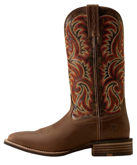 A brown leather cowboy boot with intricate multicolor embroidered swirl patterns on the shaft, a square toe, and a stacked block heel, shown against a plain white background.