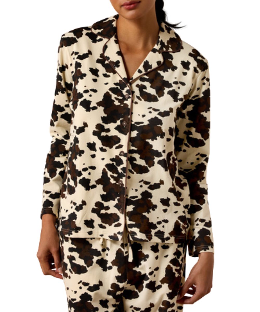 Front view of the women's shirt included in the pony play pajama set featuring the long sleeves, spread notched collar, v-neckline, button closure, and the brown and white cow print