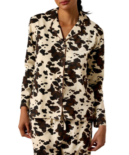 Front view of the women's shirt included in the pony play pajama set featuring the long sleeves, spread notched collar, v-neckline, button closure, and the brown and white cow print
