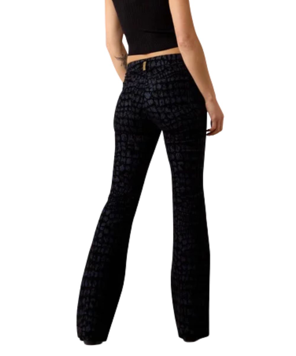 Back view of the women's black wide leg trouser jean featuring the high rise, five pocket styling, allover gator-inspired print, and a trouser hem