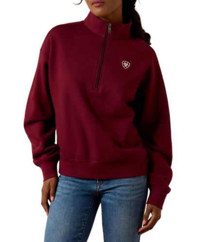 Front view of the women's wine/zinfandel Ariat long sleeve pullover sweatshirt featuring the 1/2 zip closure, mock neck, and Ariat Shield logo embroidered at the left chest