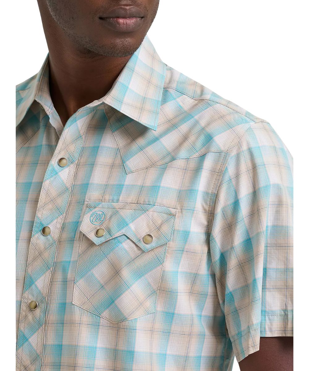 Close-up view of the men's tan and turquoise plaid snap shirt featuring single point western yokes, a spread collar, and sawtooth snap flap chest pockets.