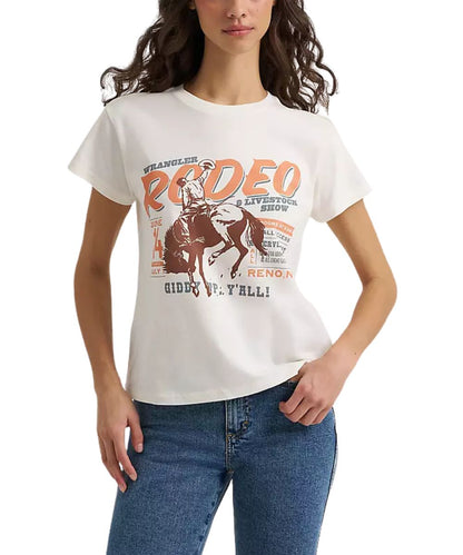 A woman wearing a white Wrangler short-sleeve t-shirt with a vintage-style orange and brown 'Rodeo' graphic, paired with blue jeans, against a plain white background.