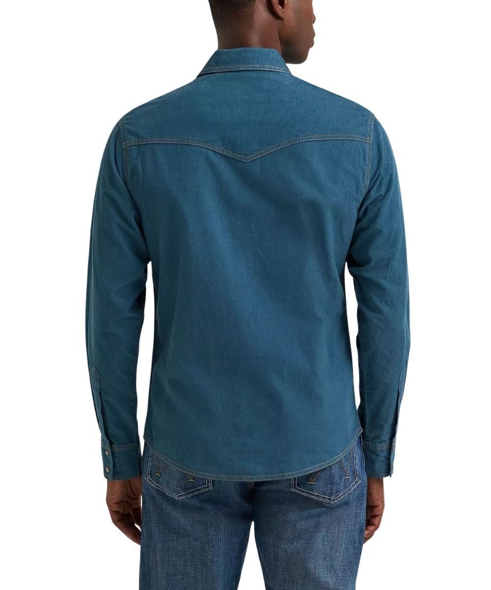 A man viewed from the back wearing a blue corduroy long-sleeve shirt and blue jeans against a plain white background.